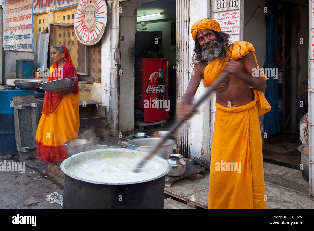 Uomo indù indossando bindi rosso sul fronte cibo di agitazione in enorme pentola per i bisognosi in Udaipur, Rajasthan, India Foto Stock