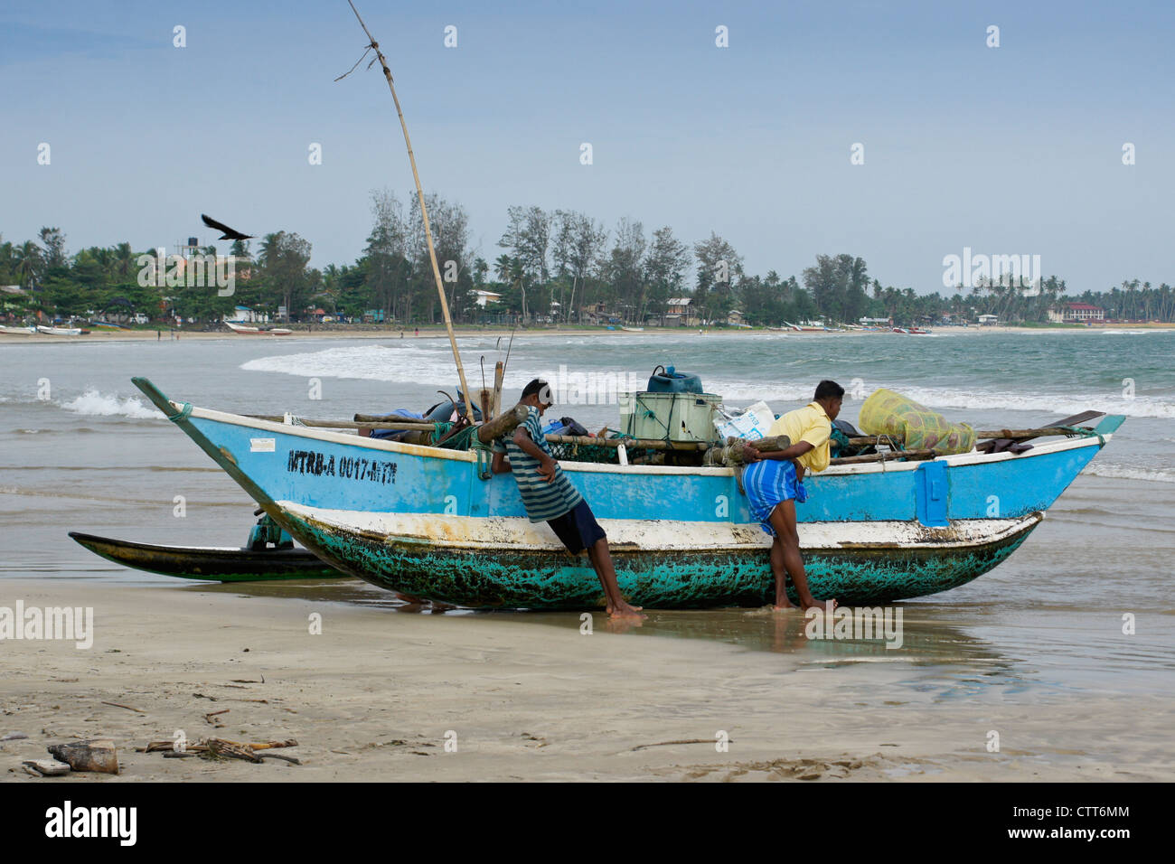 I pescatori e outrigger barca da pesca (oru o canoe) sulla spiaggia, Weligama, Sri Lanka Foto Stock