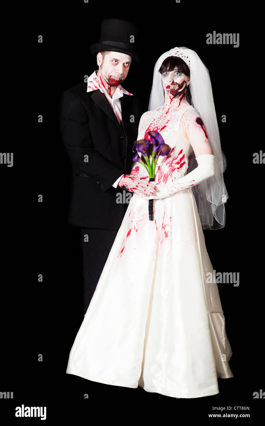 Uno zombie sposa e lo sposo posa per foto di nozze con le spose bouquet di gigli Foto Stock