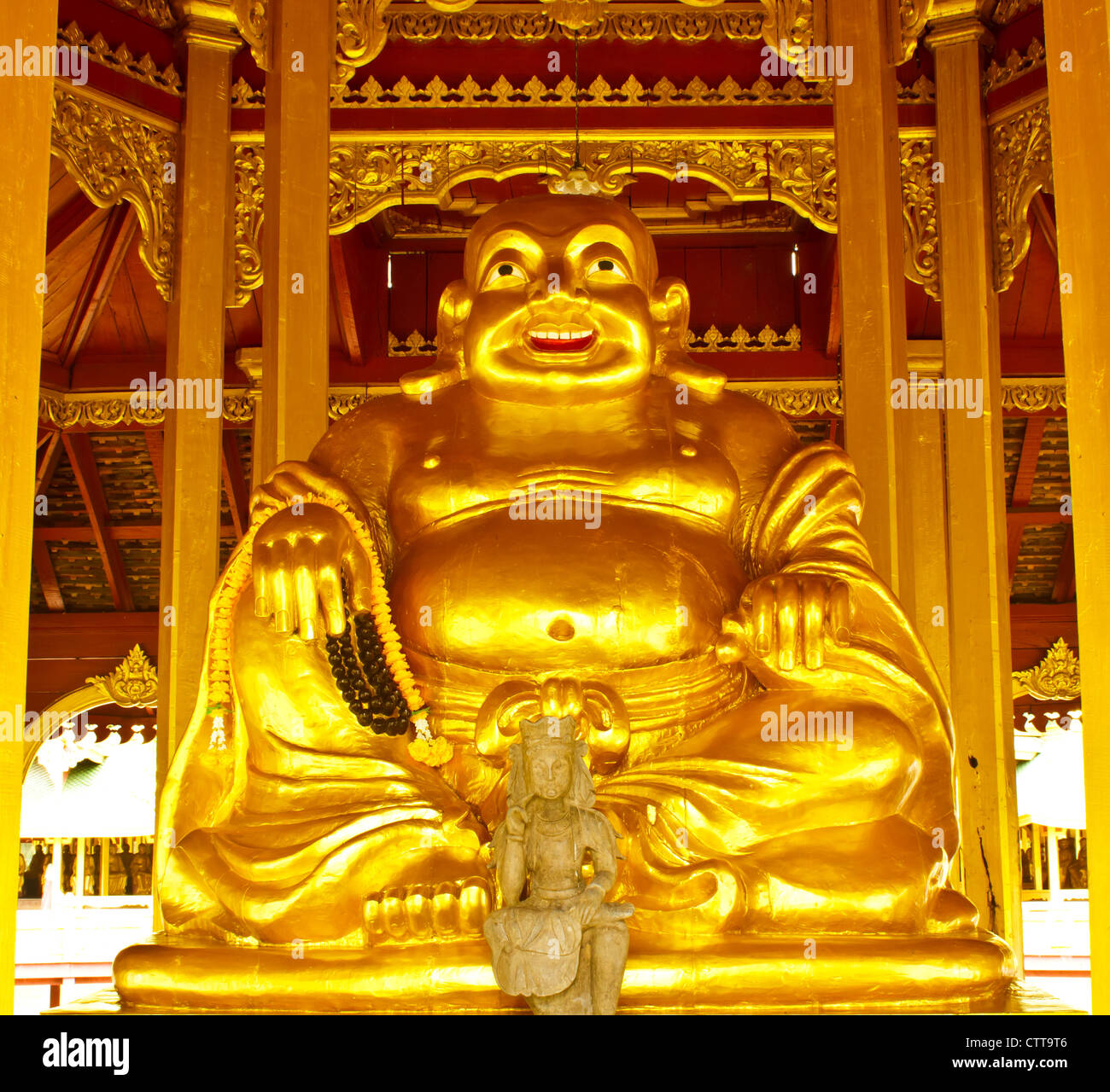 Stock Photo - sorridente Golden statua del Buddha, dio cinese di felicità, la ricchezza e la fortuna isolato su bianco Foto Stock