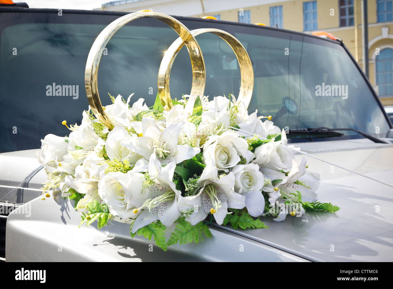 White wedding limousine decorata con fiori e anelli in oro Foto Stock