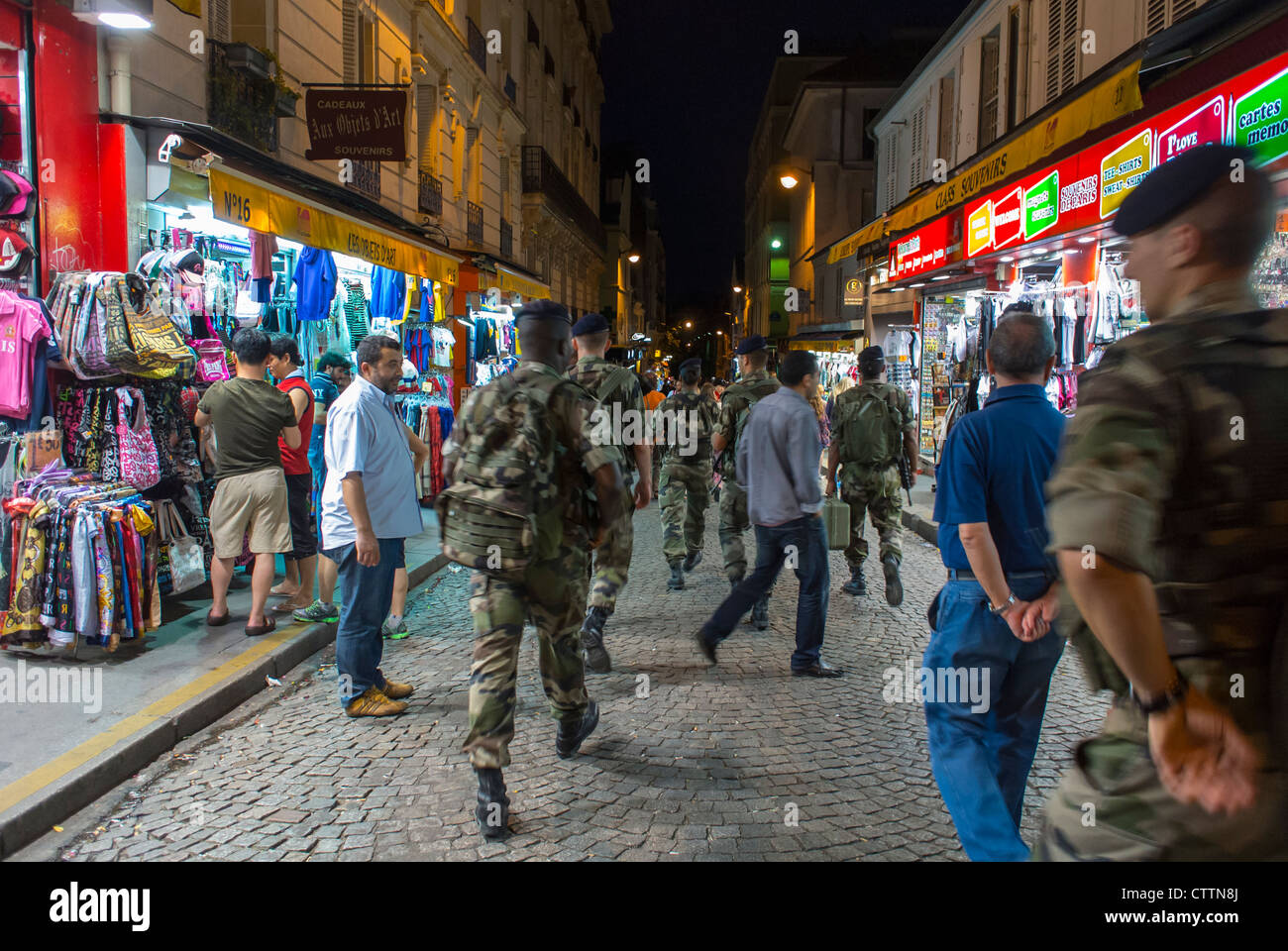 Parigi, Francia, Negozi Turistici nella zona di Montmartre, di notte, con i soldati dell'Esercito Francese che pattugliano la vivace scena di strada parigina Foto Stock