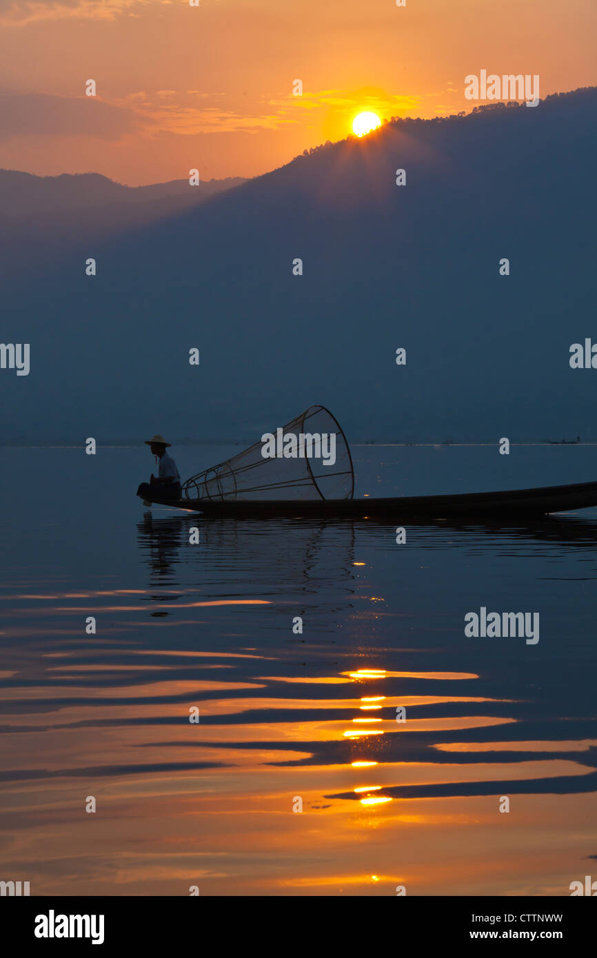 La pesca all'alba viene ancora effettuata in modo tradizionale con piccole imbarcazioni in legno, reti da pesca e gamba canottaggio - Lago Inle, MYANMAR Foto Stock