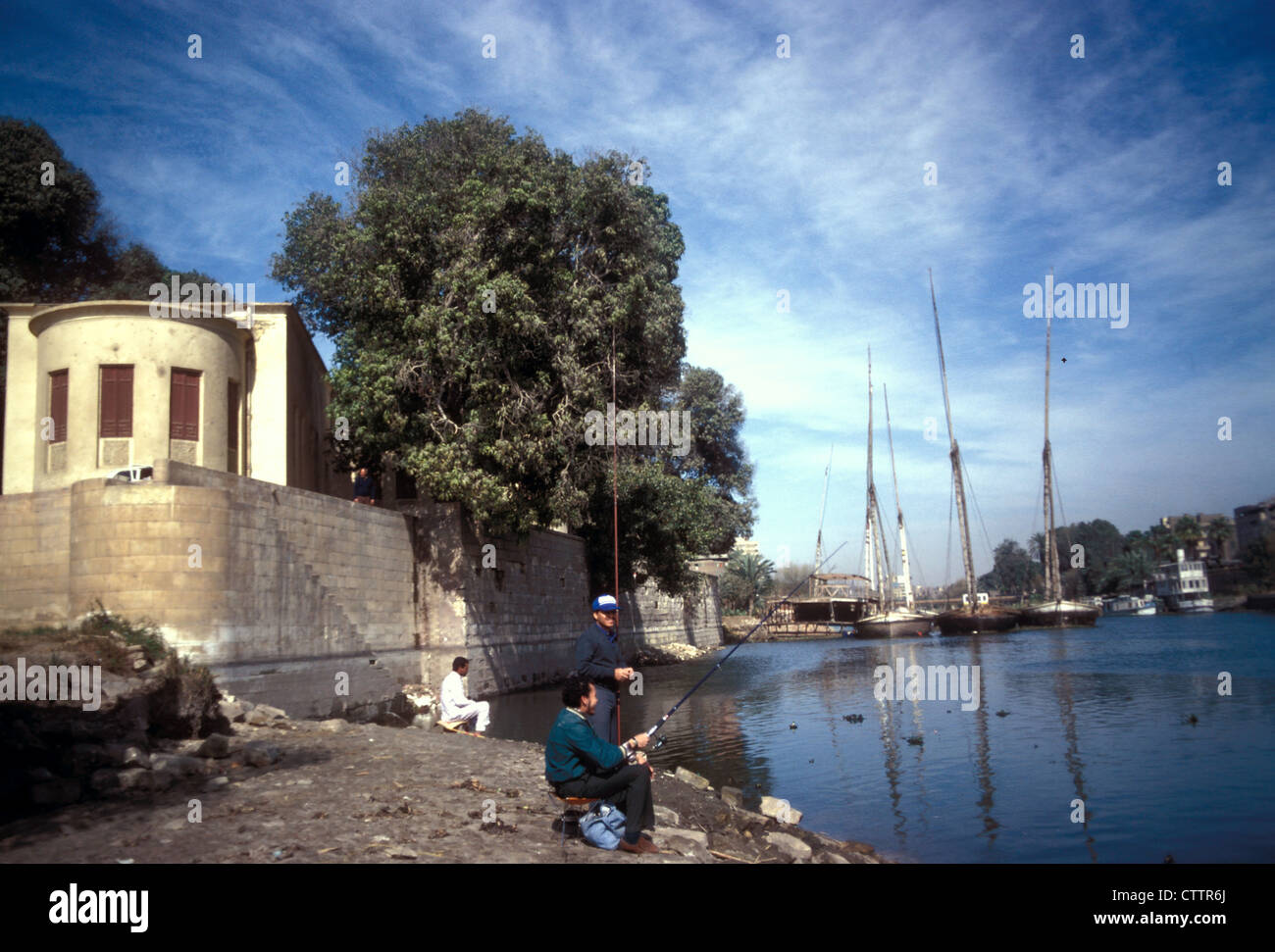 Pescatori sull'isola di Roda con l'edificio che ospita il nilometro, fiume Nilo, il Cairo, Egitto Foto Stock