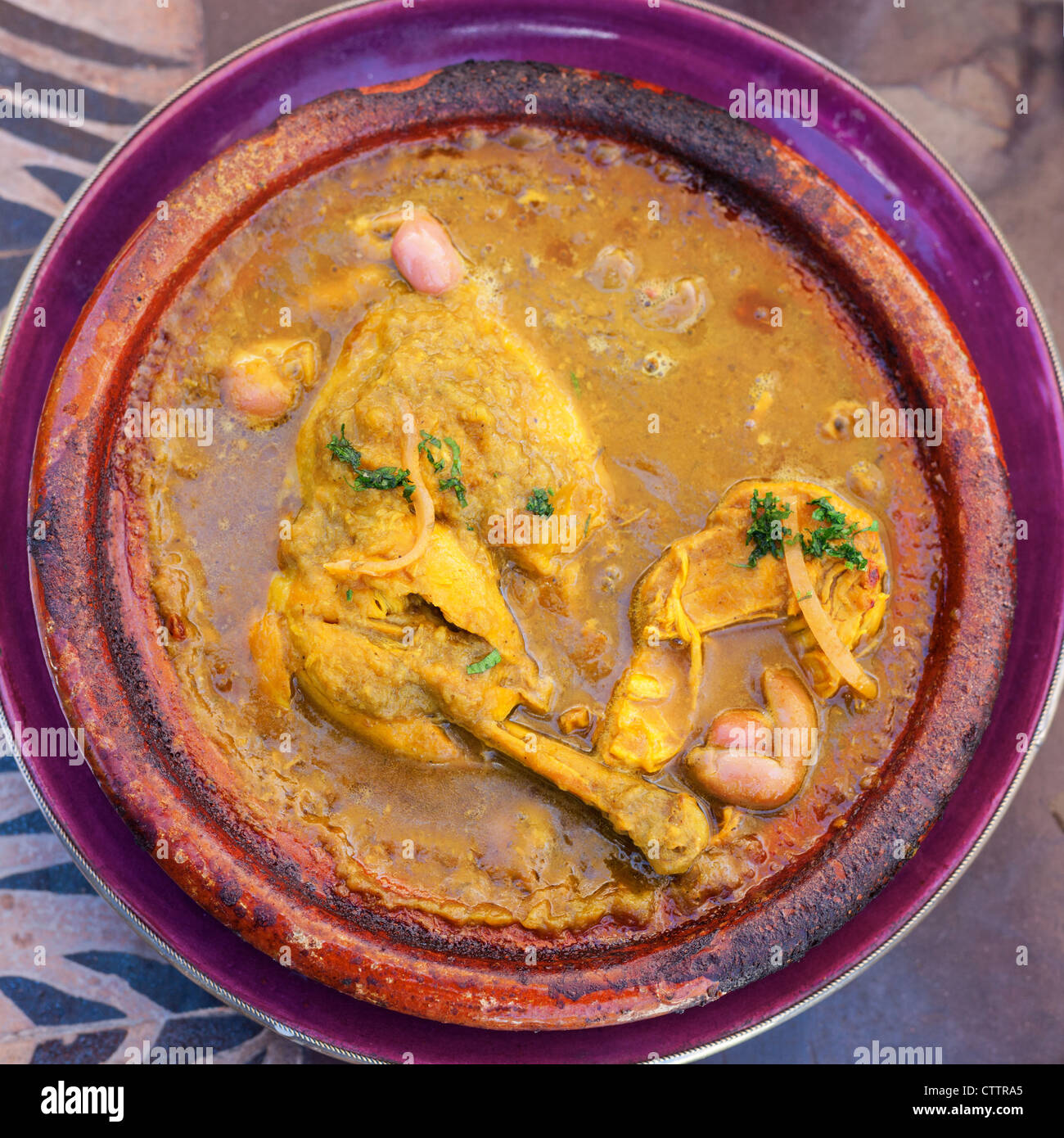 Olive e tajine di pollo fatta ​​in Marrakesh (Marocco) e servito nel piatto di argilla Foto Stock