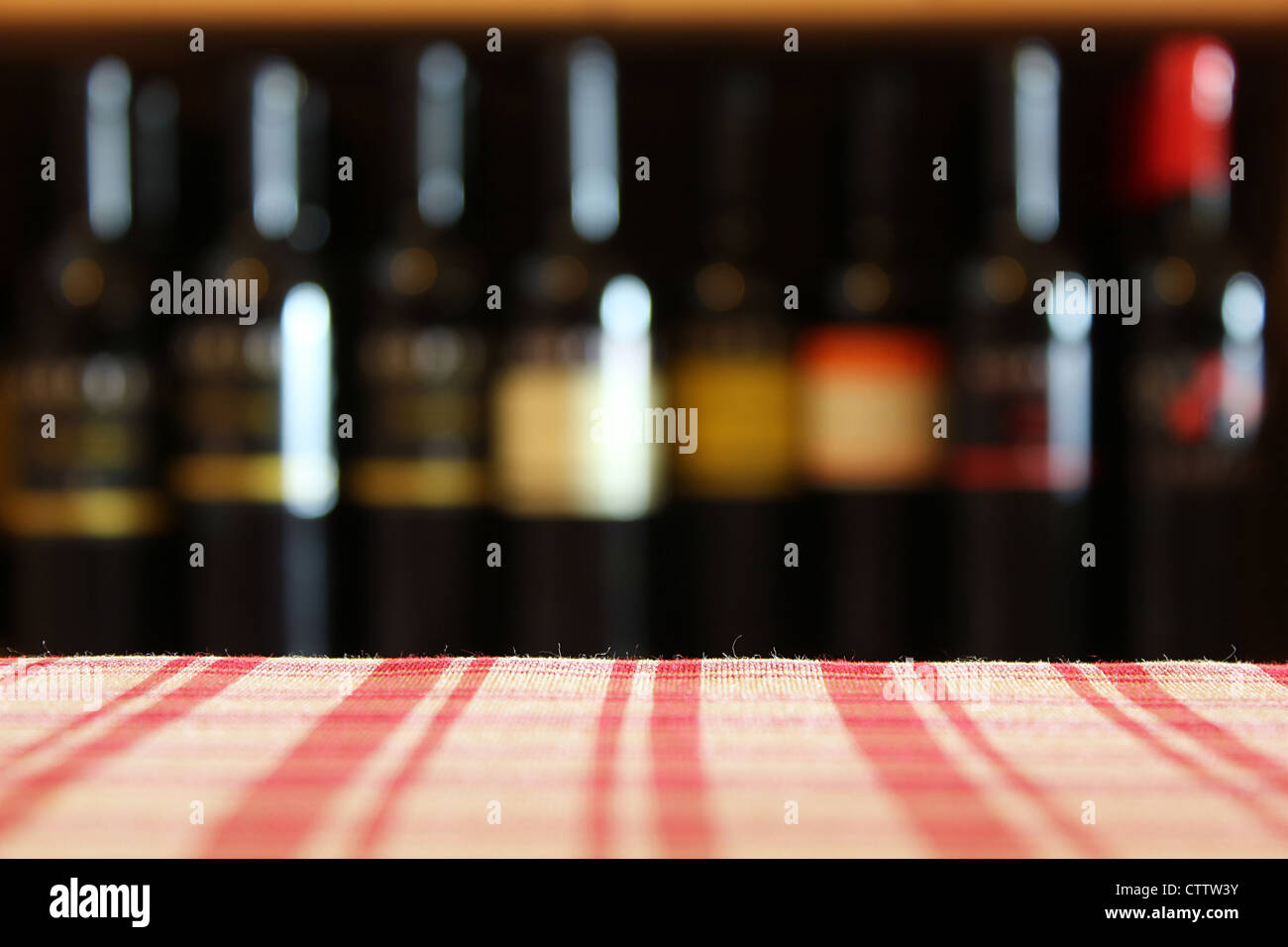 Le bottiglie di vino su un ripiano in primo piano la tovaglia shot con limitata profondità di campo Foto Stock