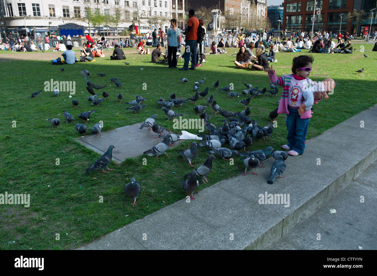 Alimentazione bambino i piccioni in Manchester Piccadilly Foto Stock