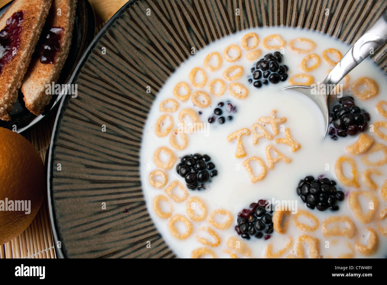 Ciotola di cereale con more e lettera pezzi sagomati l'ortografia delle parole imposta giorno galleggianti in un latte. Foto Stock