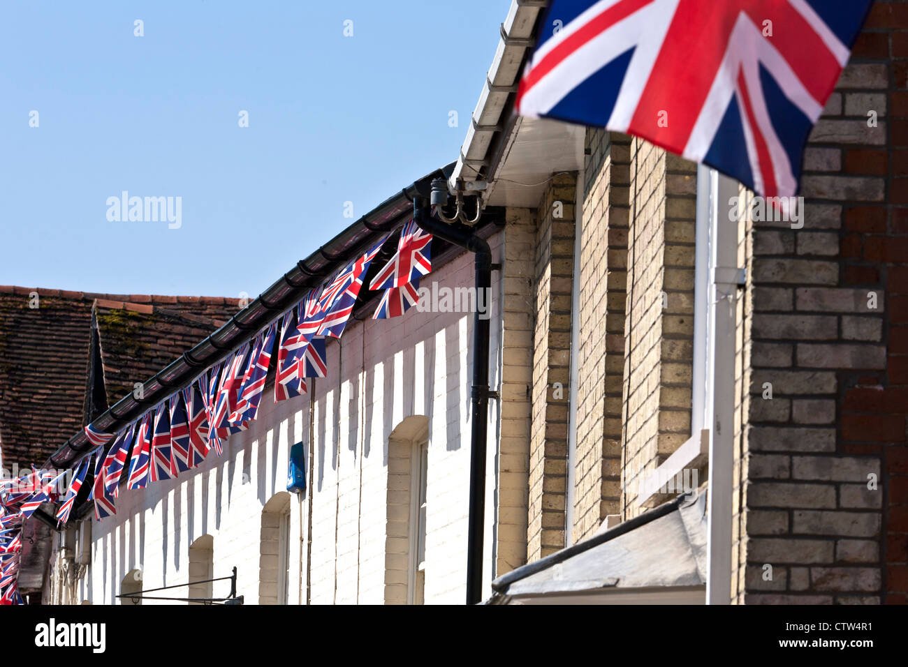 Unione di piccole bandiere usate come Bunting su edifici in inglese in paese Foto Stock