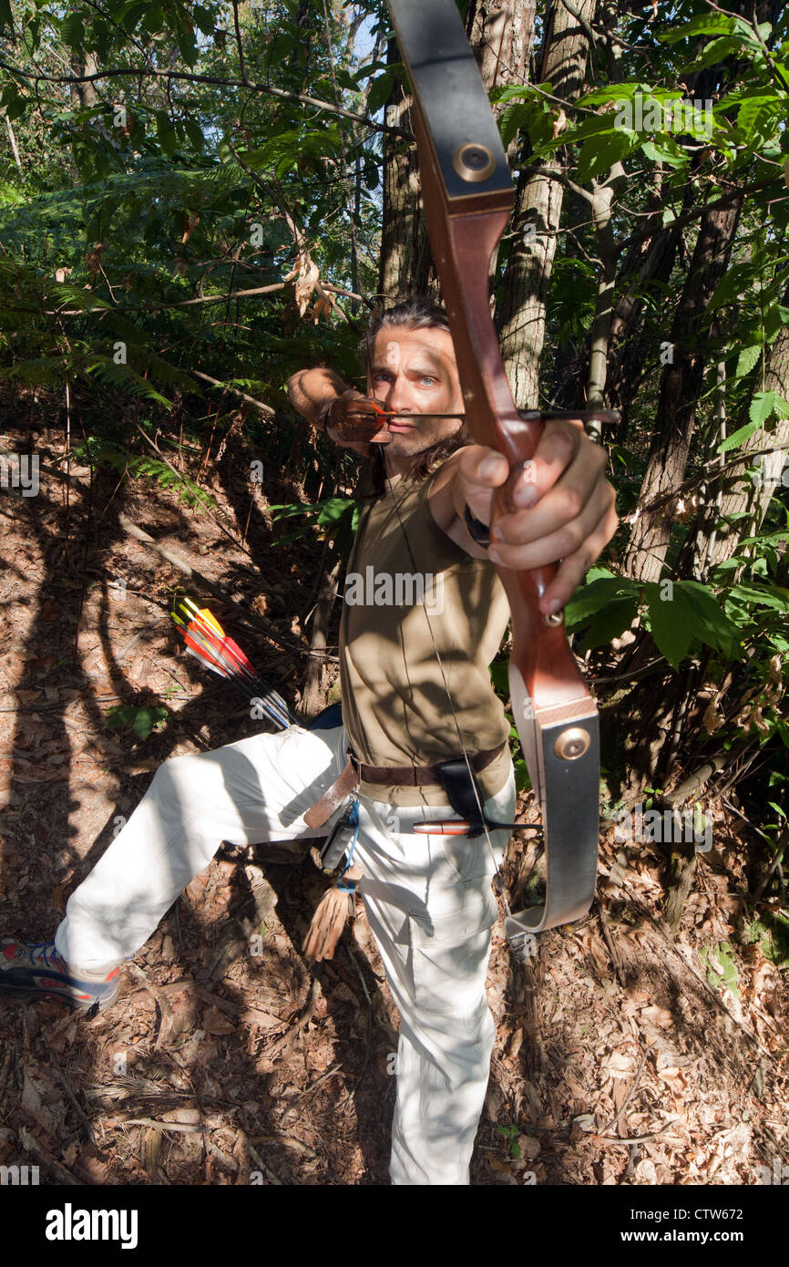 Vista frontale di un maschio di archer finalizzate alla fotocamera nel bosco Foto Stock