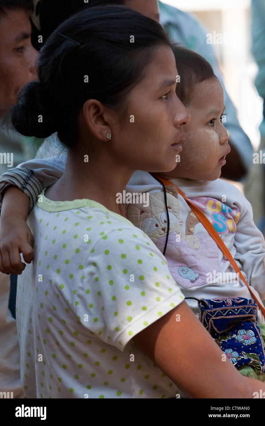 Bagan, MYANMAR Birmania. Il bambino e la madre guarda Nat Pwe ballerini. Il bambino ha thanaka incollare sul suo volto, una custodia protettiva per sun-schermo. Foto Stock