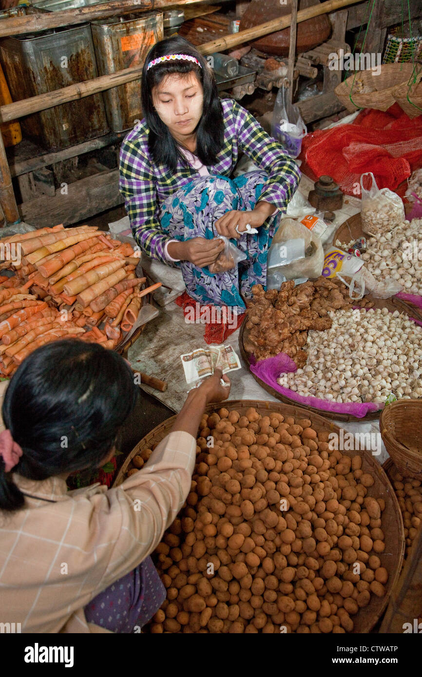 Myanmar Birmania. I clienti che acquistano un pacchetto di zenzero dal fornitore. Bagan mercato. Foto Stock