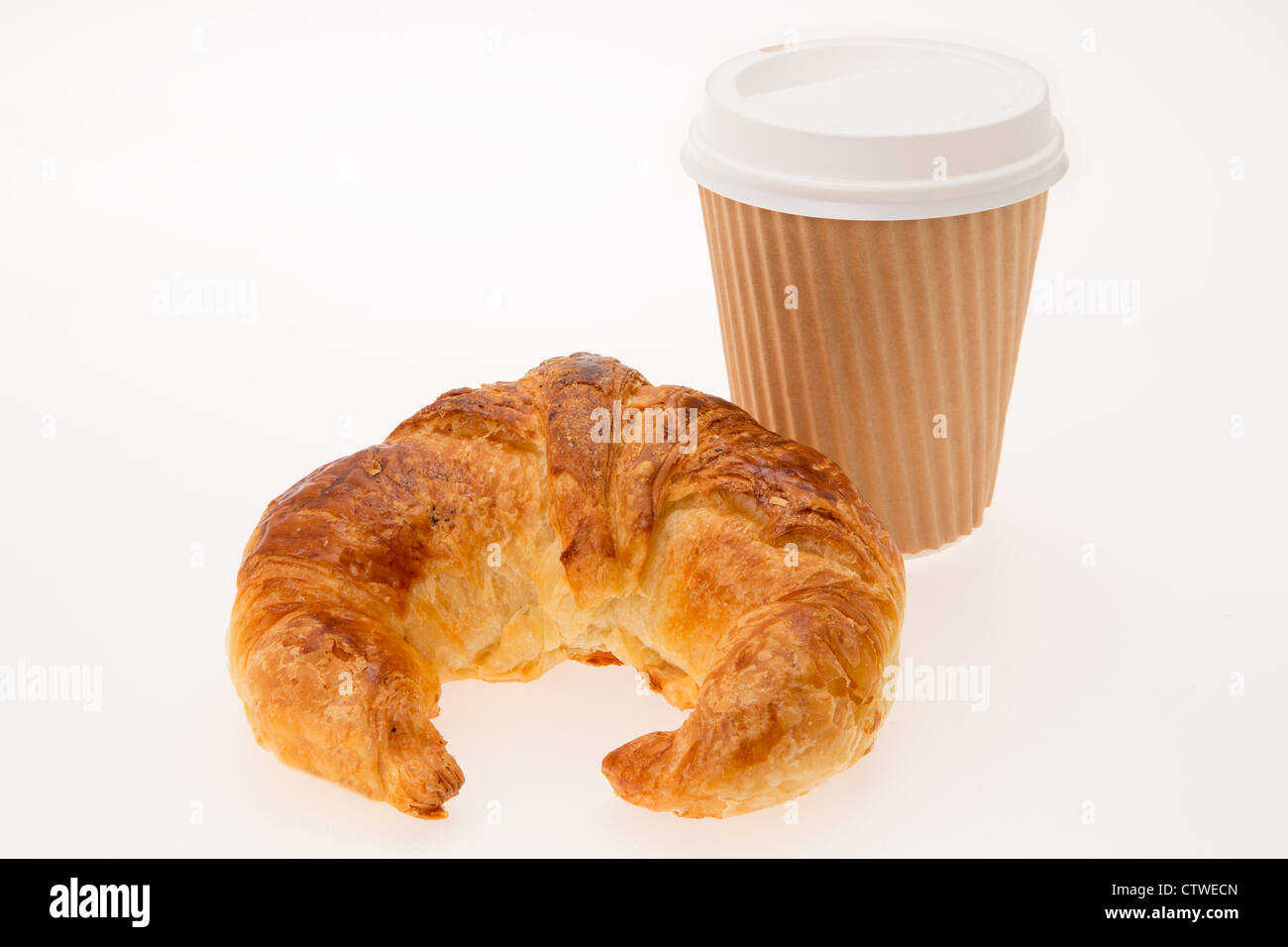 A estrarre la prima colazione consiste di un cornetto e un caffè in una tazza monouso - studio shot con uno sfondo bianco Foto Stock
