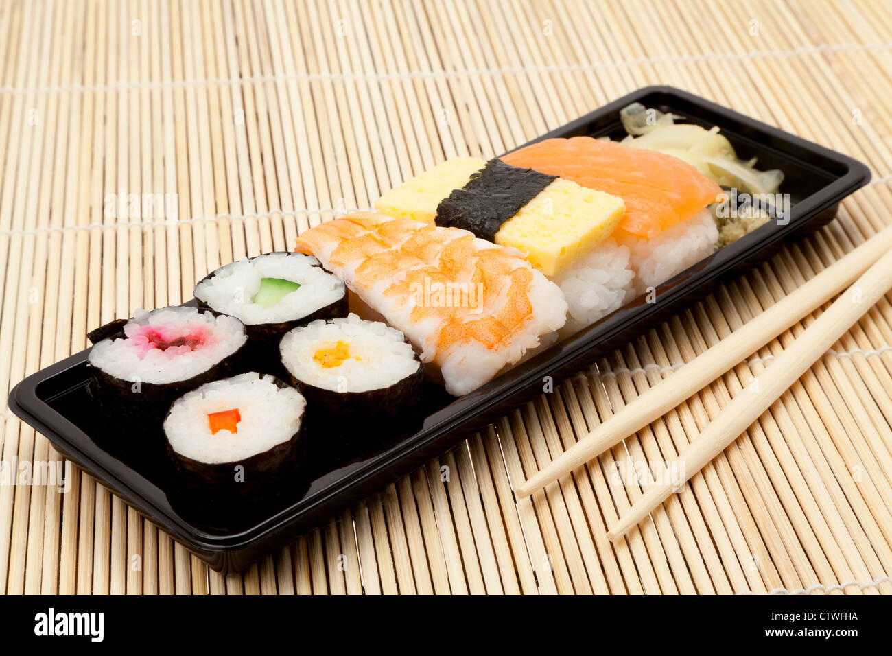 Vassoio di varie voci di Sushi su un tappetino posto con i bastoncini - studio shot Foto Stock