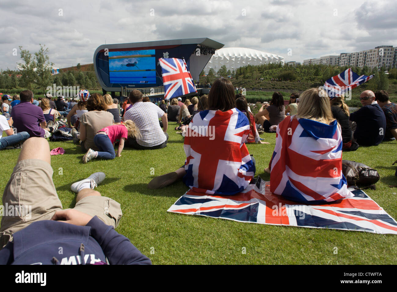 Nel Parco Olimpico, Inglesi guarda il Team GB nuotatore Rebecca Adlington in un altro calore vincente nel Parco Olimpico durante le Olimpiadi di Londra 2012. Questa terra è stata trasformata in un 2.5 sq km complesso sportivo, una volta che le imprese industriali ed ora sede di otto luoghi di interesse tra cui il principale arena, Aquatics Centre e Velodromo plus degli atleti del Villaggio Olimpico. Dopo le Olimpiadi, il parco è noto come Queen Elizabeth Olympic Park. Foto Stock