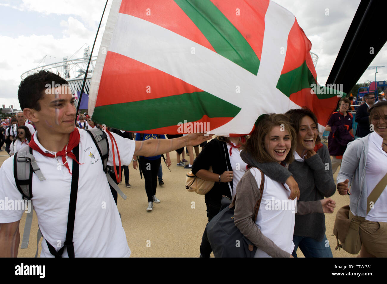 Gli spettatori da Bayonne francesi nella regione basca, a piedi attraverso il parco olimpico durante le Olimpiadi di Londra 2012. Questa terra è stata trasformata in un 2.5 sq km complesso sportivo, una volta che le imprese industriali ed ora sede di otto luoghi di interesse tra cui il principale arena, Aquatics Centre e Velodromo plus degli atleti del Villaggio Olimpico. Dopo le Olimpiadi, il parco è noto come Queen Elizabeth Olympic Park. Foto Stock