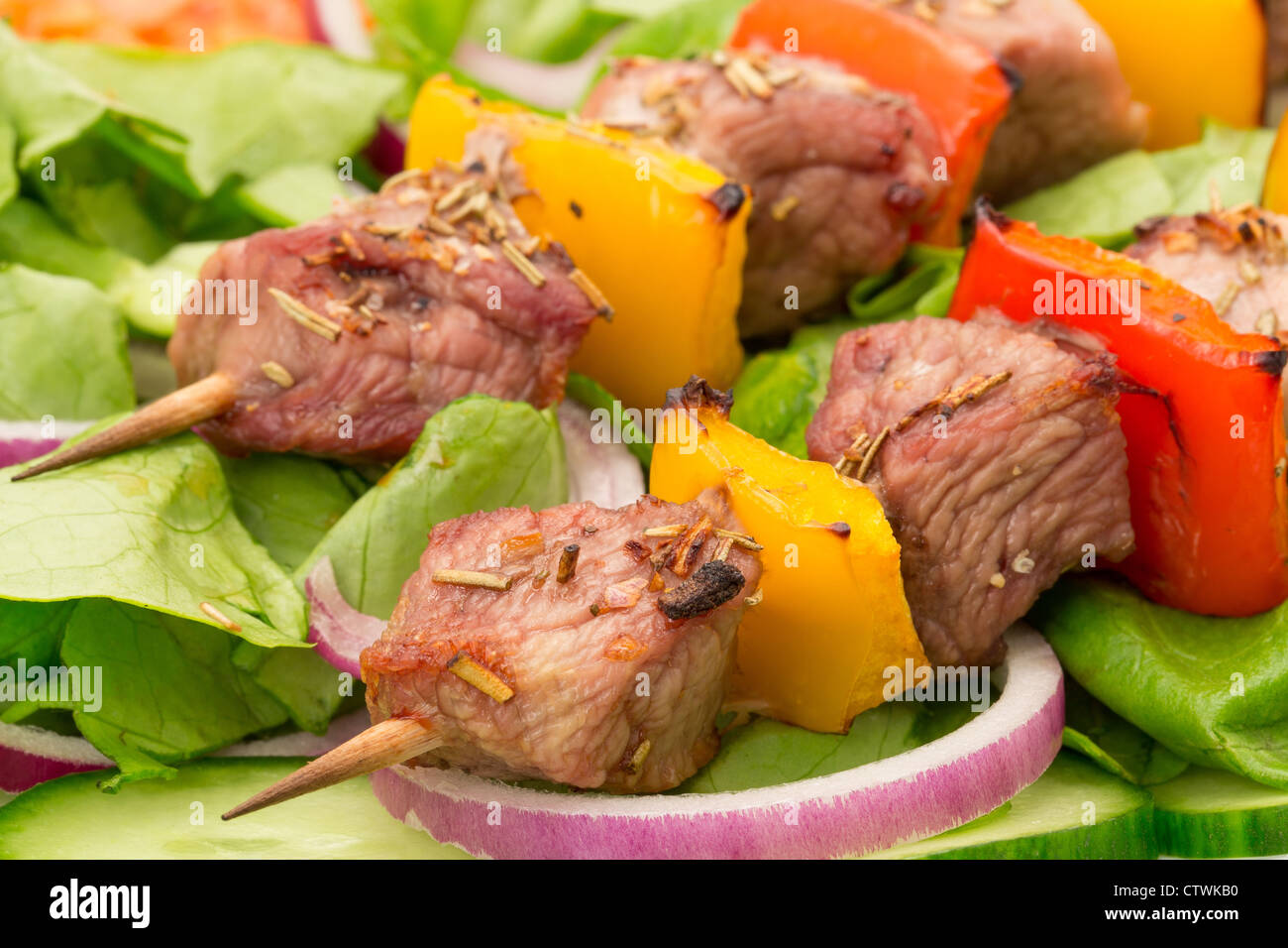 Spiedini di carne di maiale o Souvlaki servito su un letto di insalata - studio shot Foto Stock