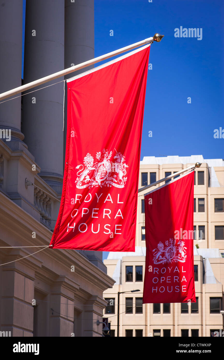 Londra Covent Gardens Royal Opera House facciata anteriore red flag banner fiamme battenti bandiera poli sole estivo soleggiato sunshine Foto Stock