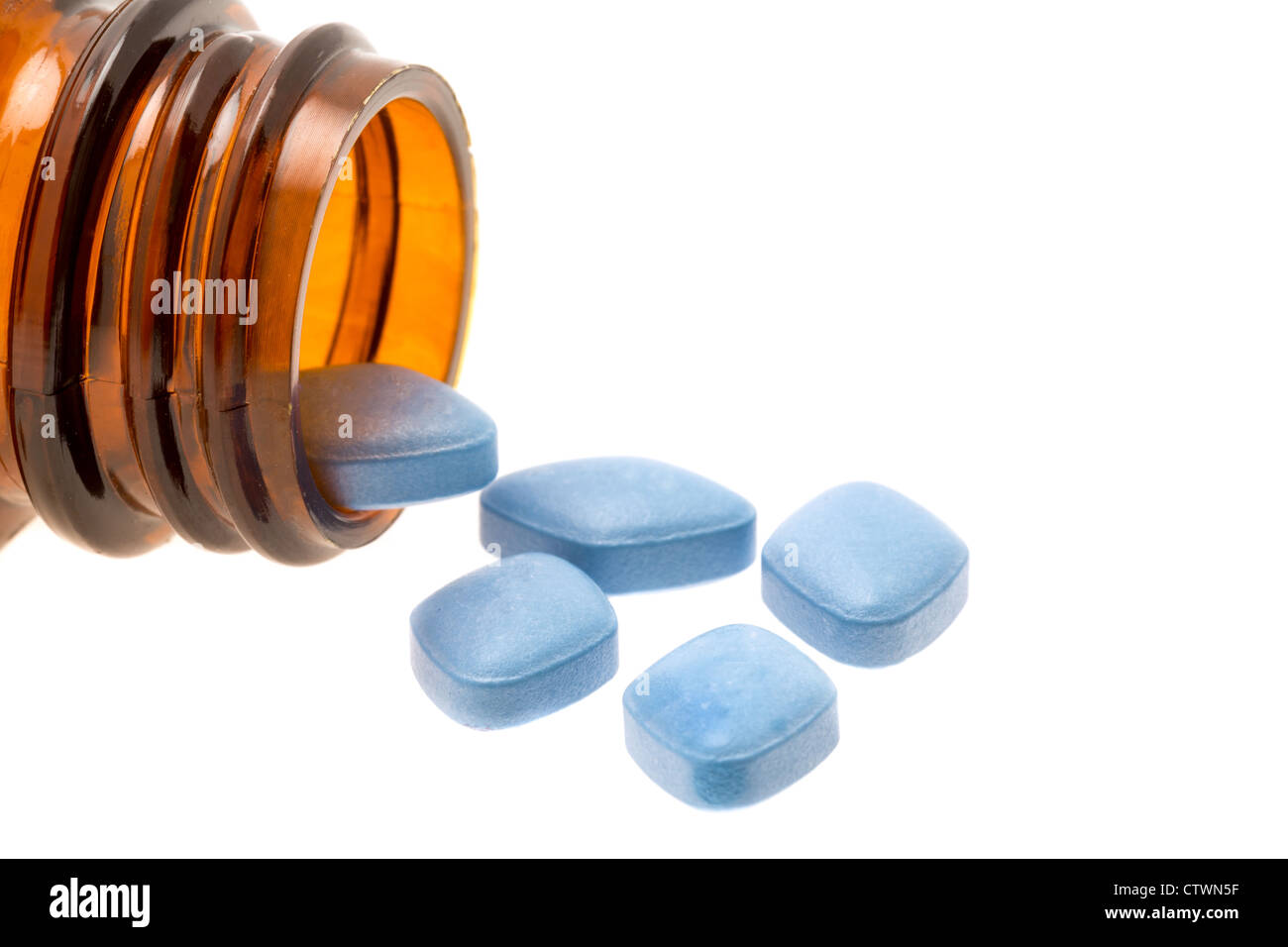 Blu Viagra anti-impotenza compresse versata da una bottiglia su uno sfondo bianco. Foto Stock