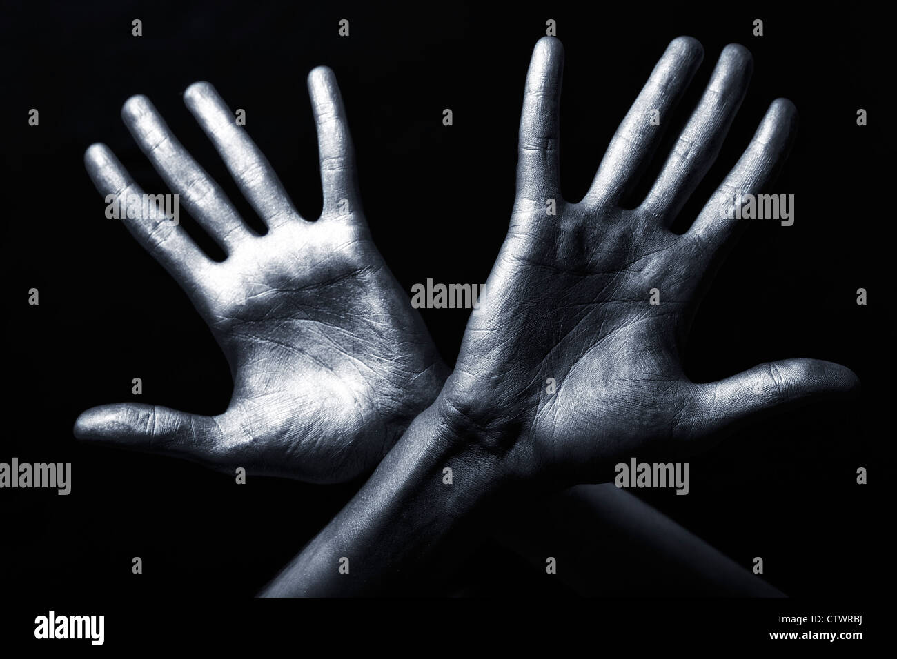 Gli uomini la mano in una vernice argento isolato su sfondo nero Foto Stock