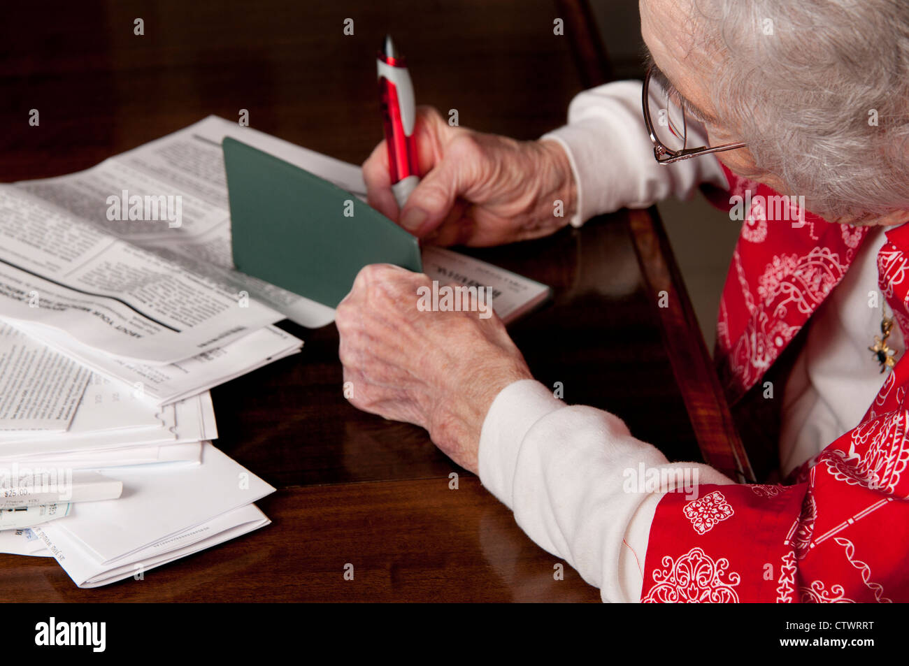 Donna anziana la scrittura di un controllo e di pagare la finanza personale fatture Foto Stock