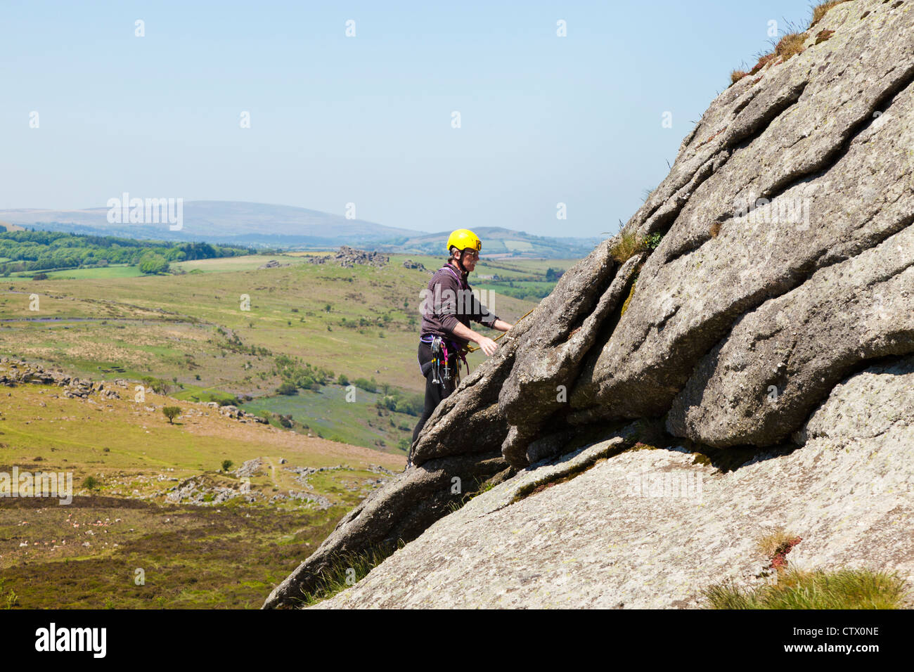 L'uomo arrampicata su Haytor Rocks, un granito tor su Dartmoor Devon, Regno Unito Foto Stock