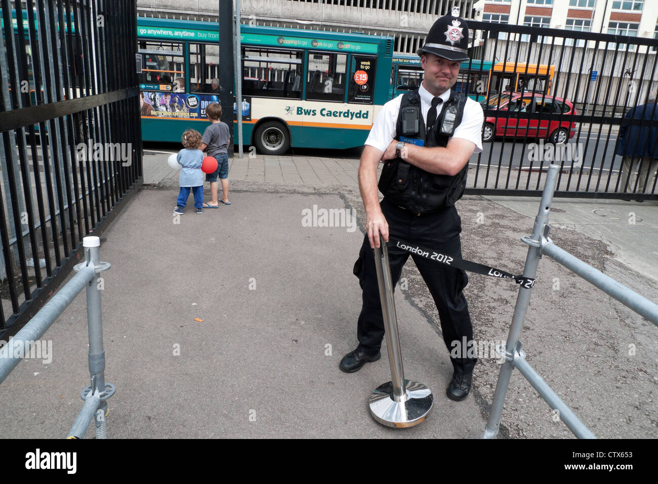 Poliziotto tenendo un bollard con una Londra 2012 segno il logo al di fuori del Millennium Stadium Cardiff City Centre Wales UK Foto Stock