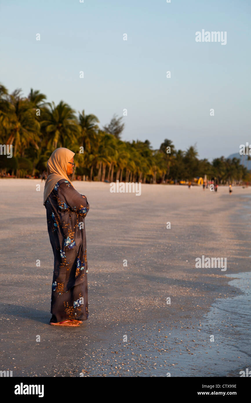Donna musulmana sulla Spiaggia di Pantai Cenang Pulau Langkawi Malaysia. Foto Stock