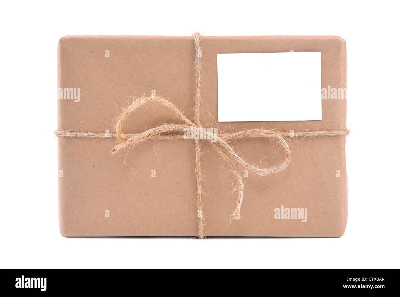 Un pacco avvolto in carta marrone e legati con spago ruvido e etichetta vuota Foto Stock