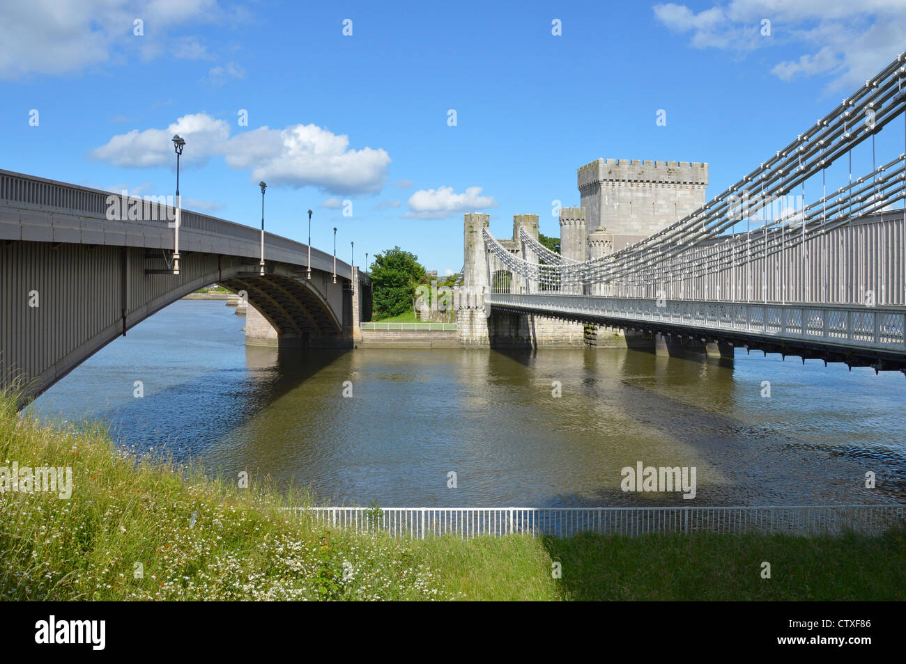 Moderna strada ponte vecchio di sinistra Telford road Suspension Bridge & Stephenson ferro battuto ferroviaria tubolare ponte che attraversa il fiume Conwy Foto Stock