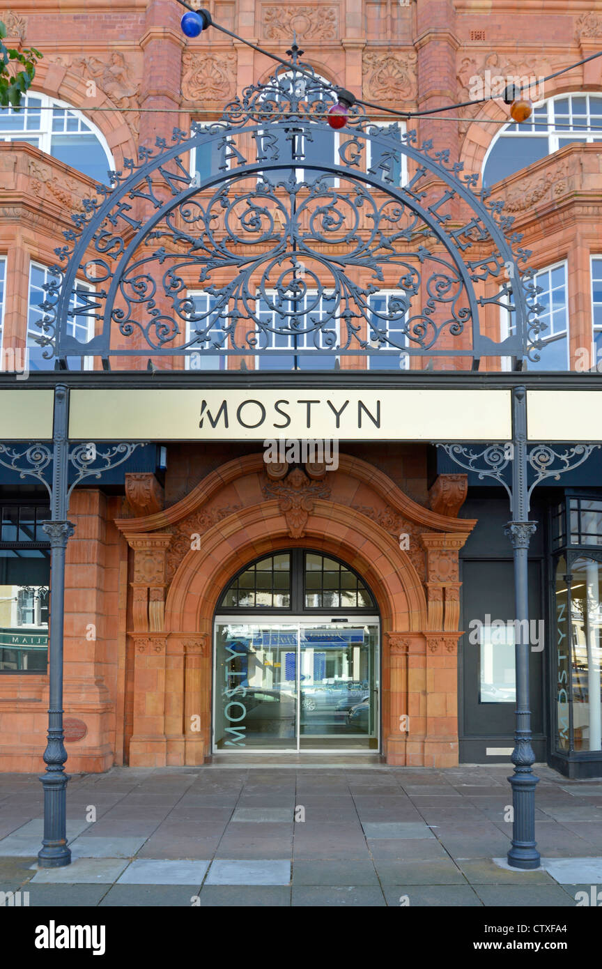 Oriel Mostyn, una galleria d'arte pubblica di beneficenza, vicino a una parte dell'edificio storico e a moderne porte d'ingresso con facciata in terracotta Llandudno, Galles del Nord, Regno Unito Foto Stock