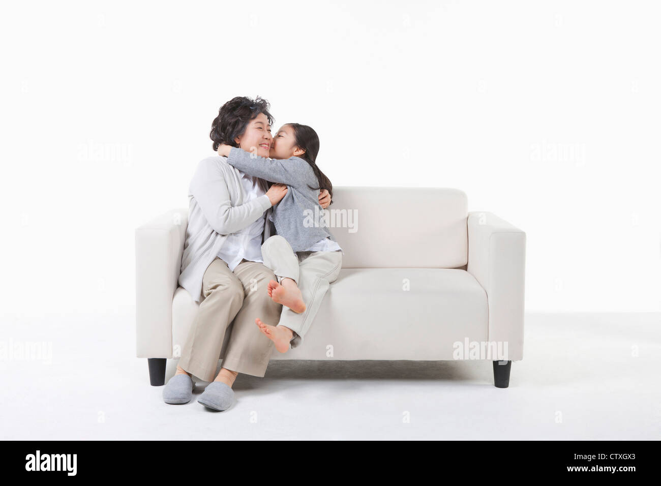 Un nipote baciare sulla nonna guancia Foto Stock