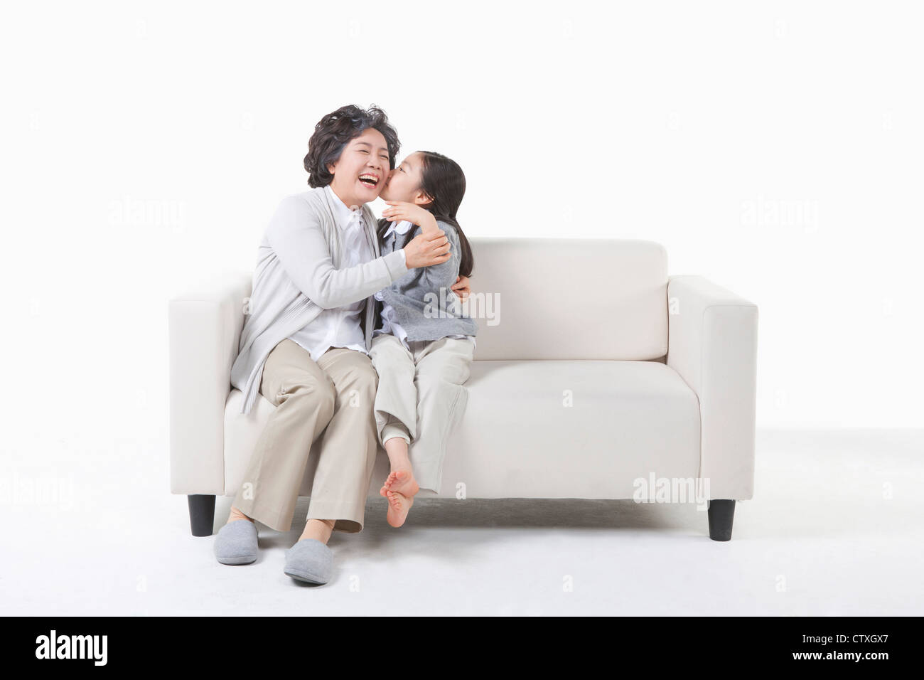 Un nipote baciare sulla nonna guancia Foto Stock