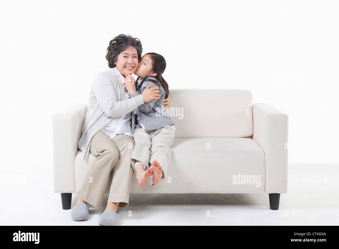 Un nipote baciare sulla nonna guancia Foto Stock