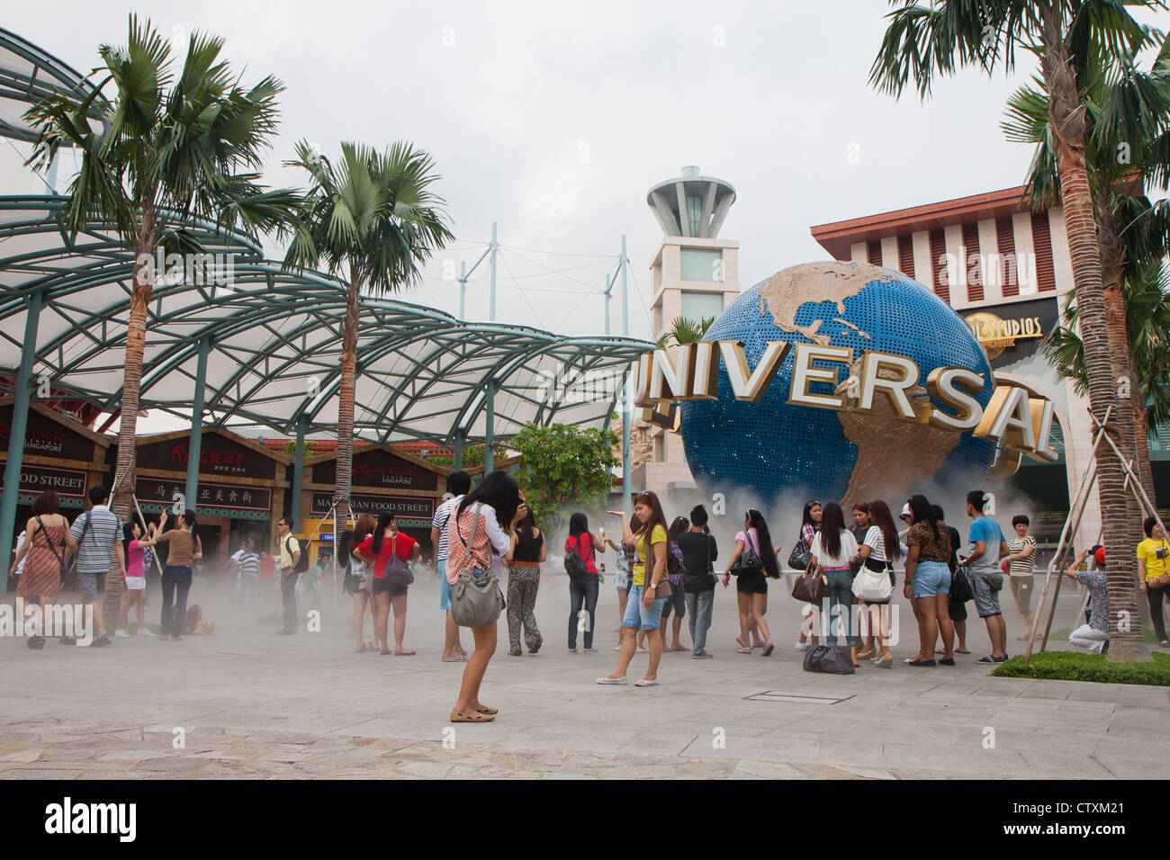 SINGAPORE - Marzo 2012 - i turisti in posa vicino agli Universal Studios logo e marchio di fabbrica in Sentosa Resorts World, Singapore. Foto Stock