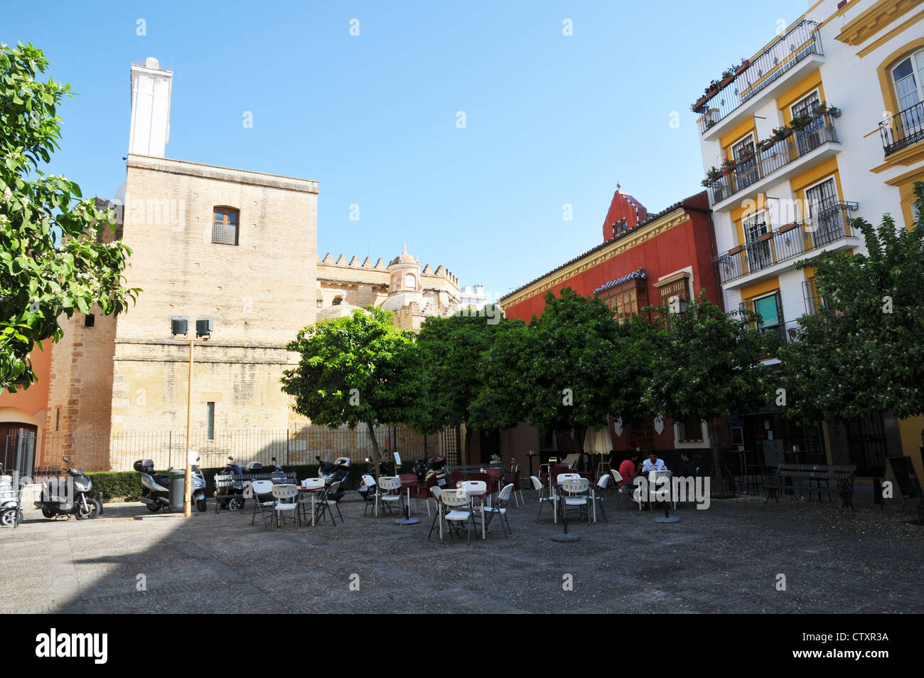 Le persone al di fuori seduta in piazza, chiesa, stile classico spagnolo case, centro di Siviglia, Spagna. Foto Stock