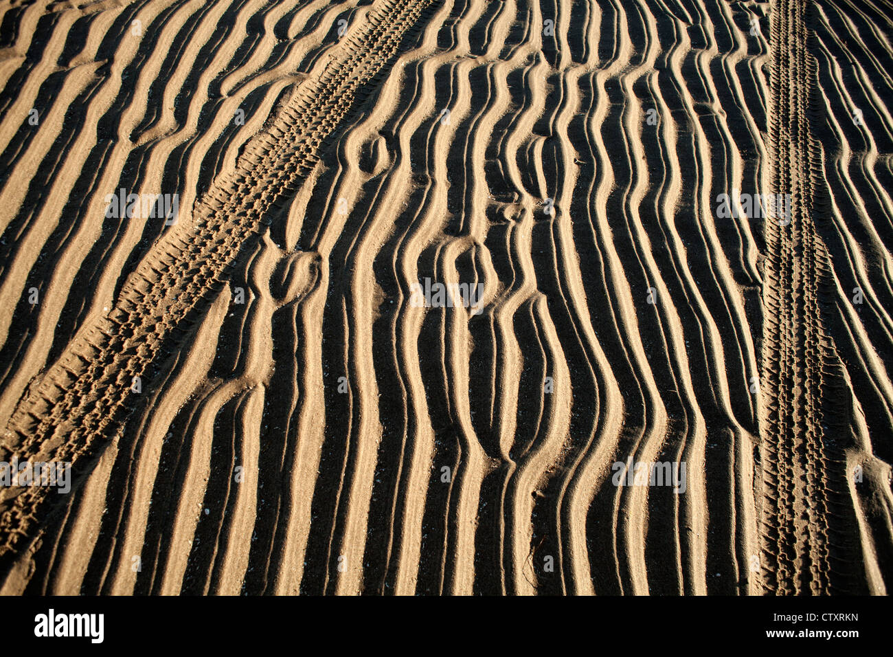 Fotografia astratta di texture pattern tracce di pneumatici e il ripple di sabbie a sinistra a bassa marea sulla spiaggia con la bassa marea sulla spiaggia Foto Stock