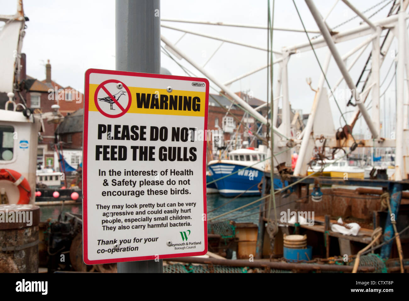Non alimentare i gabbiani segno a Weymouth Harbour dalle barche da pesca Foto Stock