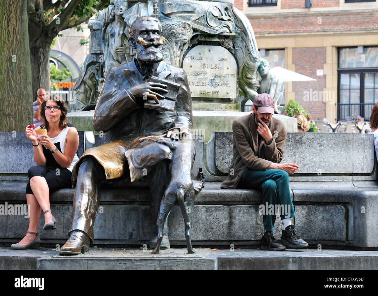 Bruxelles, Belgio. Memoriale di Charles / Karel Buls. La donna a mangiare il gelato, uomo seduto pensando Foto Stock