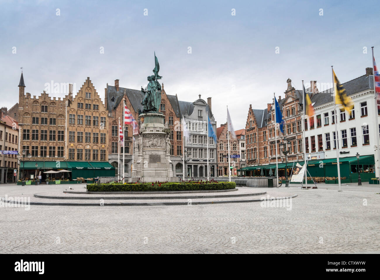 Bandiere che sventolano attorno ad una statua di Jan Breydel e Pieter De Coninck mattina presto a Brugge Piazza del Mercato Foto Stock