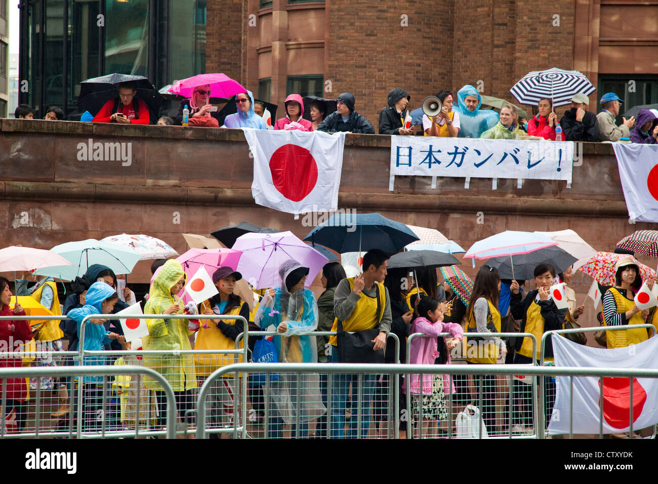 Atletica giapponese sostenitori di attendere nella pioggia per le donne di maratona, Olympic Games, Londra, 2012. Foto Stock