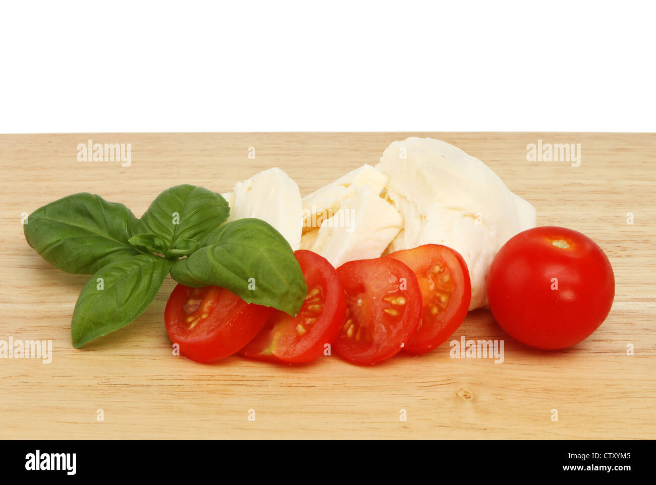 Basilio, pomodoro e mozzarella su una tavola di legno Foto Stock