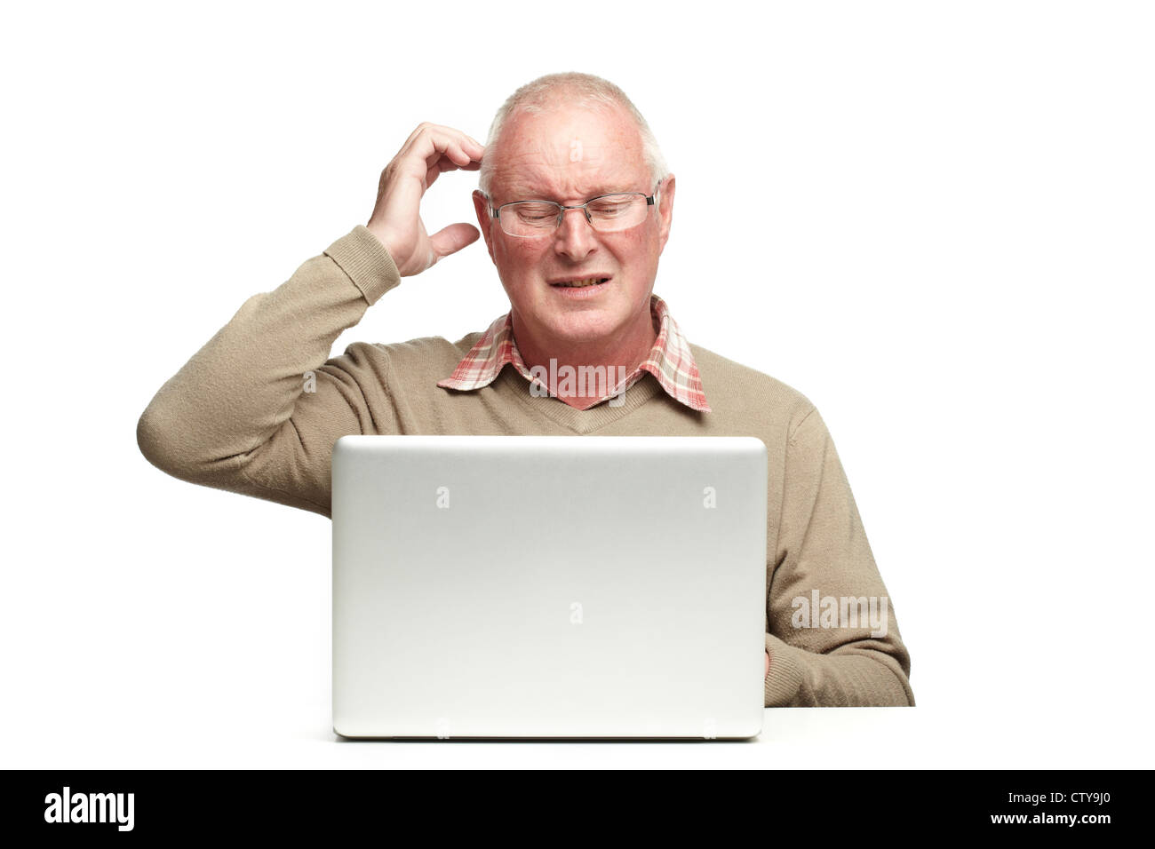 Senior uomo utilizzando portatile mentre cercando confuso su sfondo bianco Foto Stock