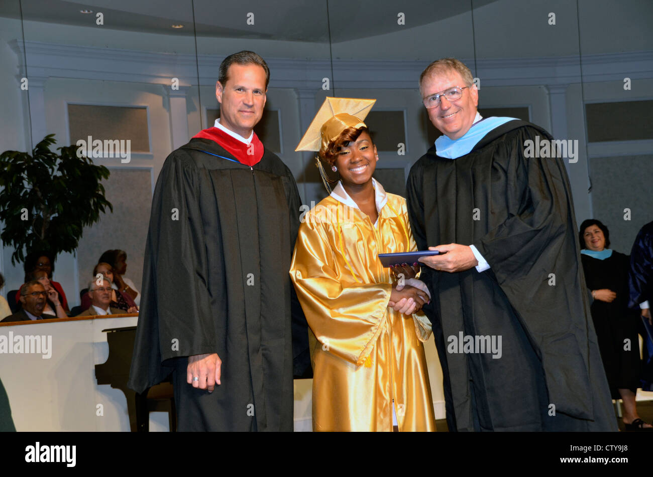 Un diplomato si è aggiudicata il suo diploma di scuola superiore dei responsabili della scuola presso la sua laurea Foto Stock