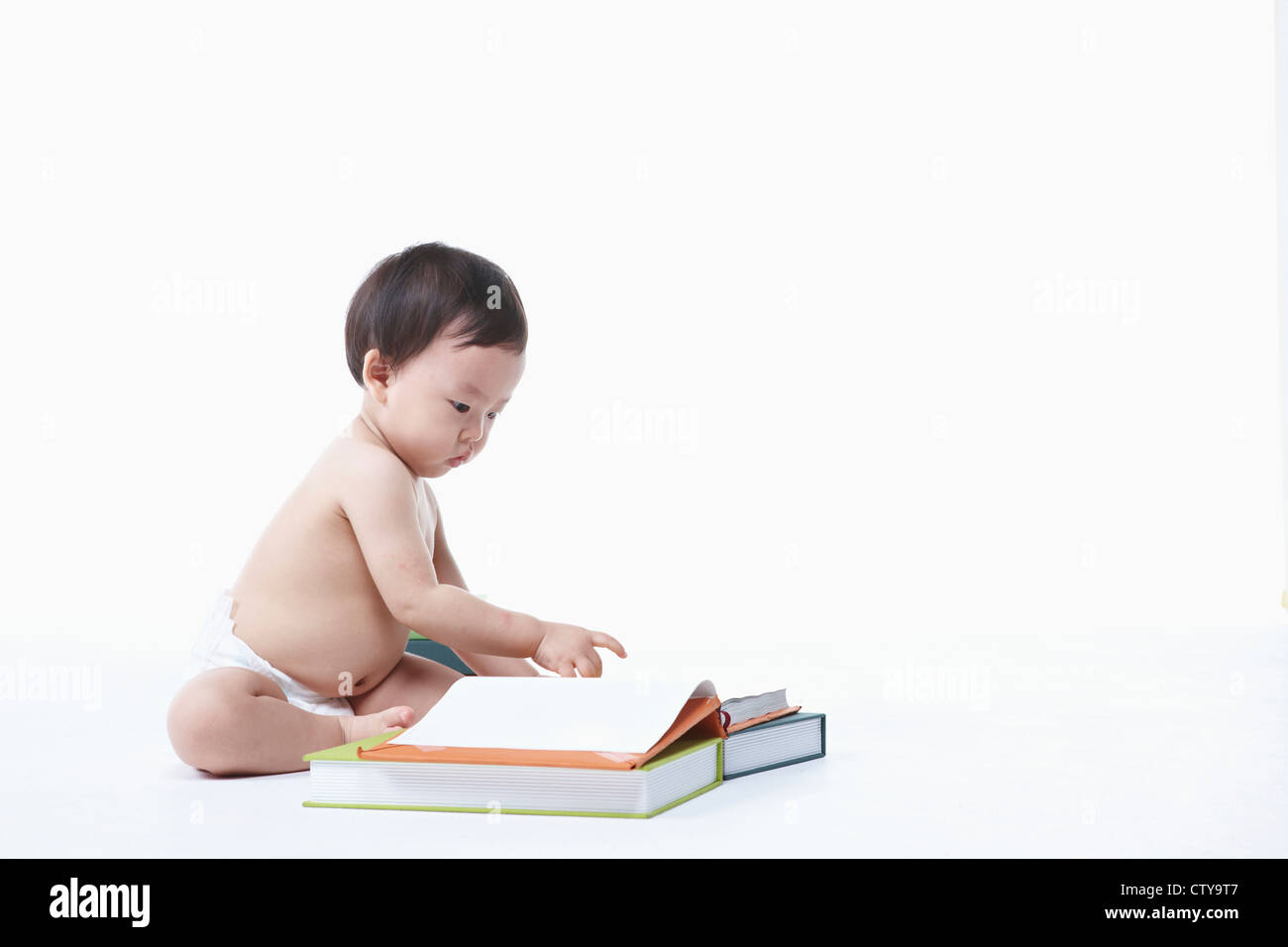 Un bambino seduto intorno i libri Foto Stock