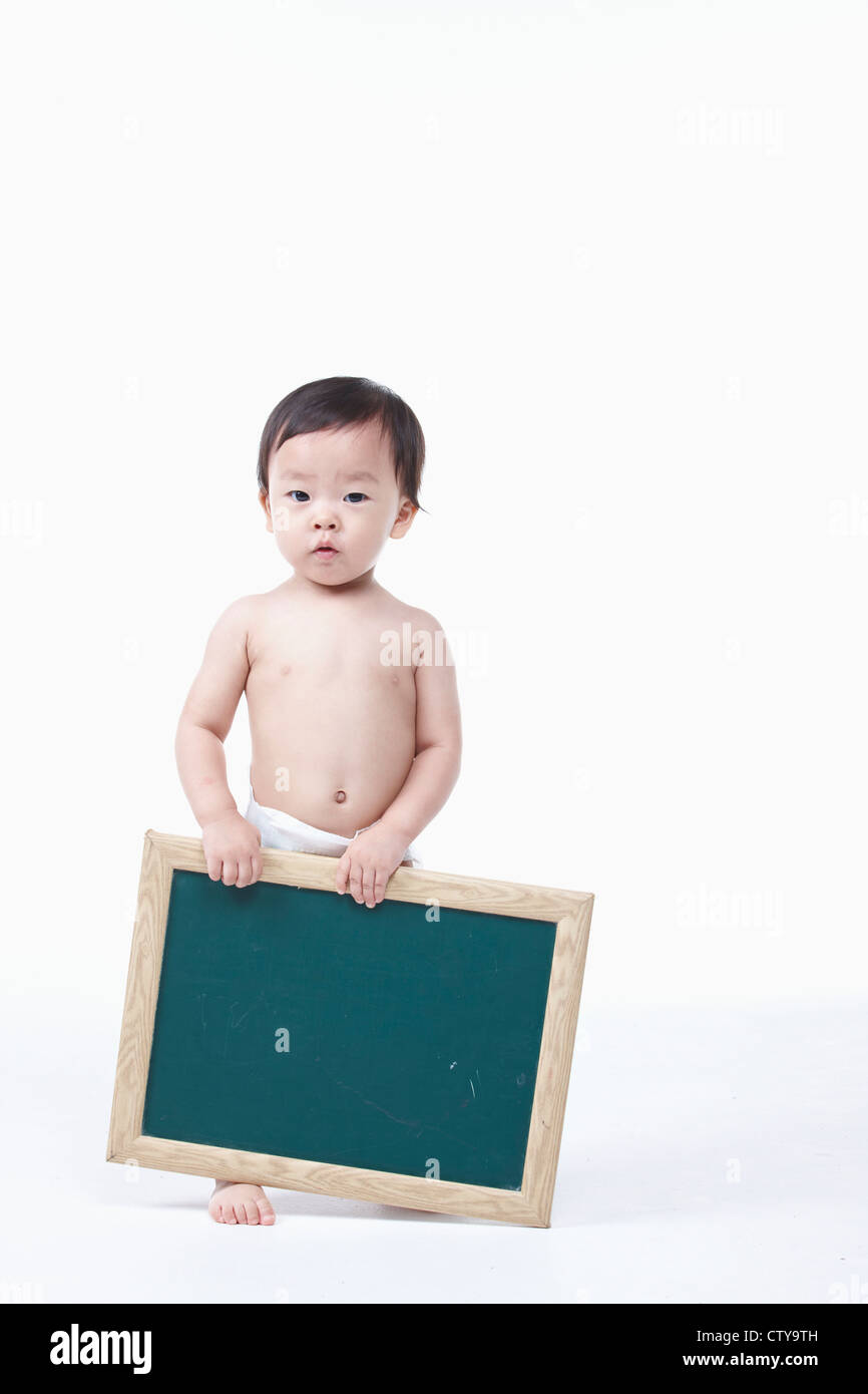 Un bambino tiene una lavagna Foto Stock