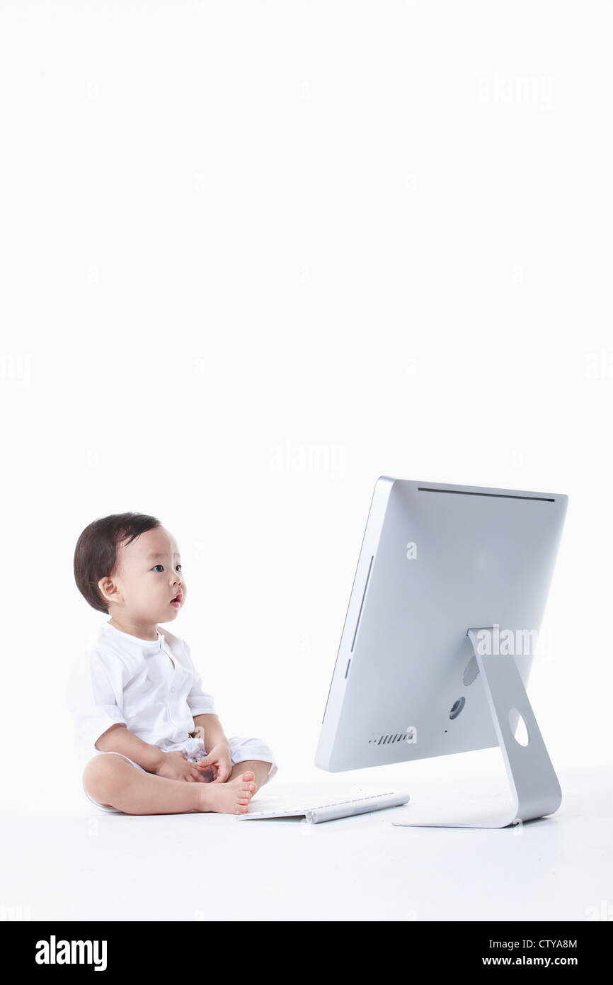 Un bambino seduto con un computer Foto Stock