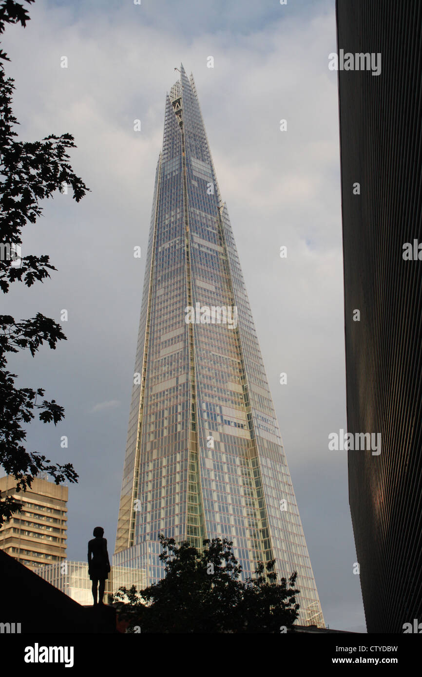 Shard contrastato contro la statua femminile e albero Foto Stock