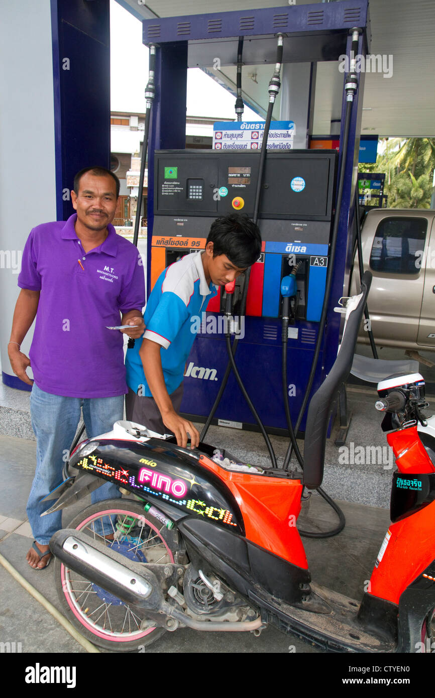 Gas station attendant riempiendo uno scooter a motore sull isola di Ko Samui, Thailandia. Foto Stock