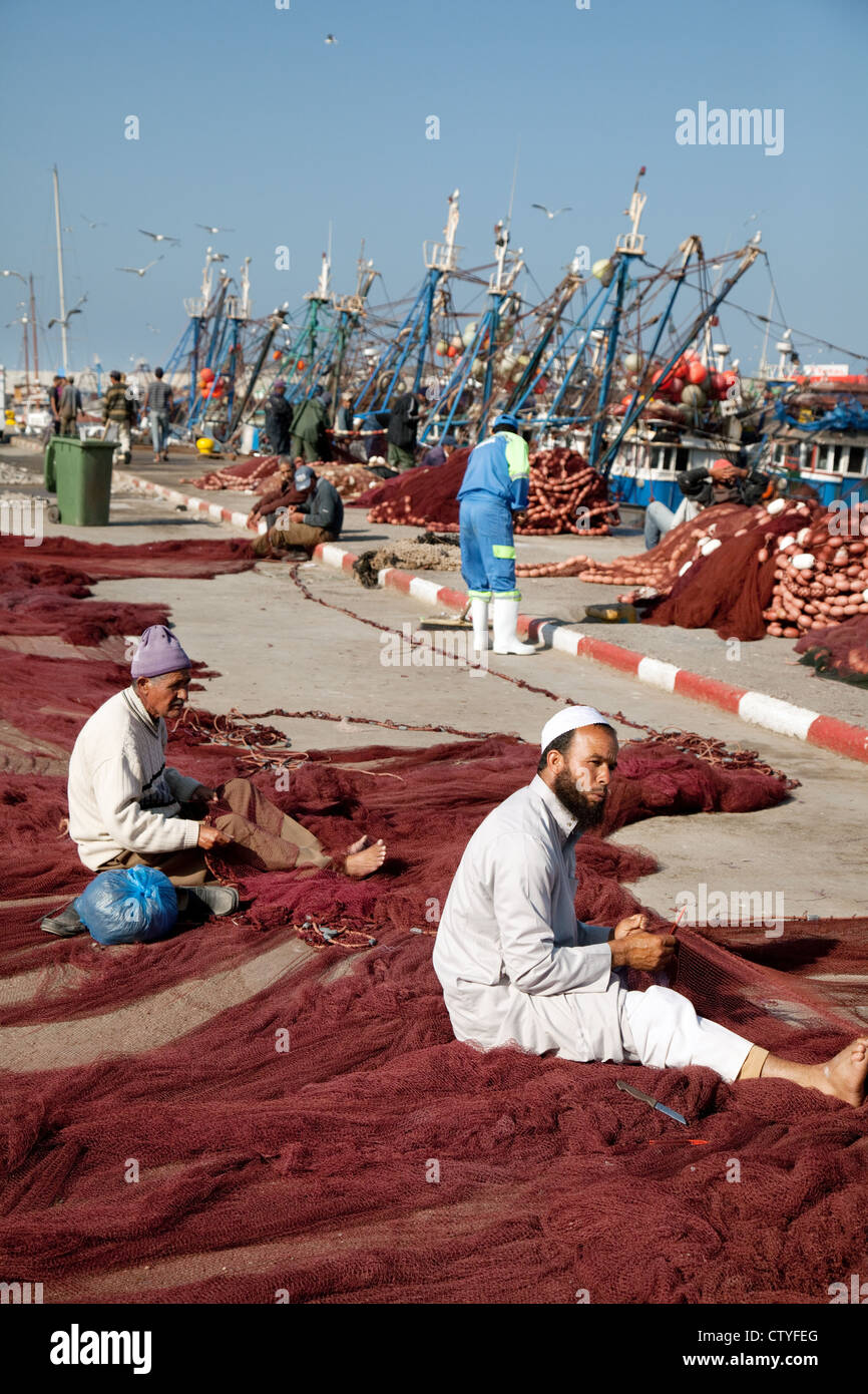 Arab berber i pescatori che lavorano sulle loro reti da pesca, il porto essaouira marocco Africa Foto Stock